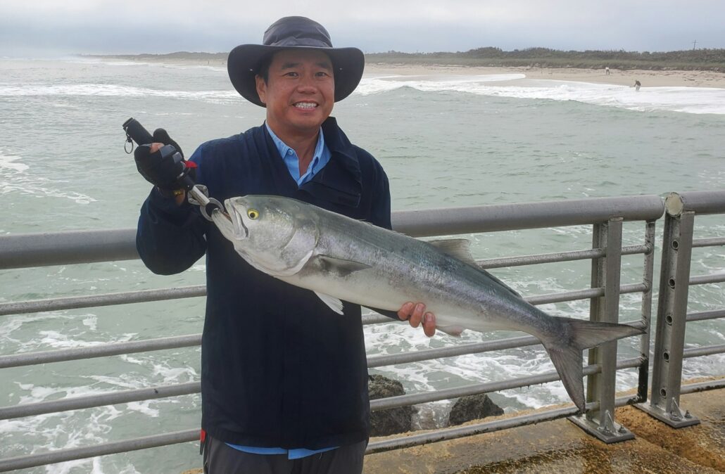 Augustine Chan and a beefy bluefish he caught while fishing at the tip of the south jetty Friday morning.